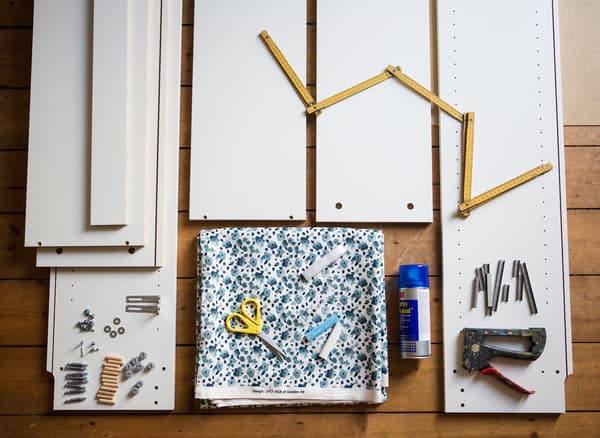 Fabric, pieces of a bookcase, and tools laid out on the floor.
