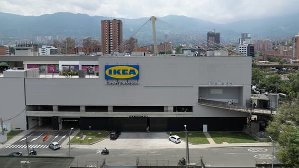 Fachada de la tenda IKEA de Medellin desde un edificio al frente. En la imagen se ve un edificio con un gran logo de la marca IKEA colgado de sus paredes.