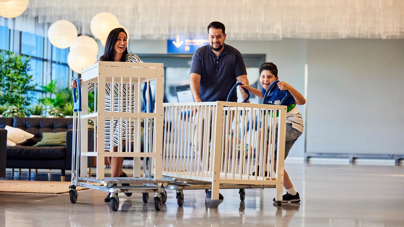 Familia transporta en carros una cuna y cambiador del surtido de Ikea