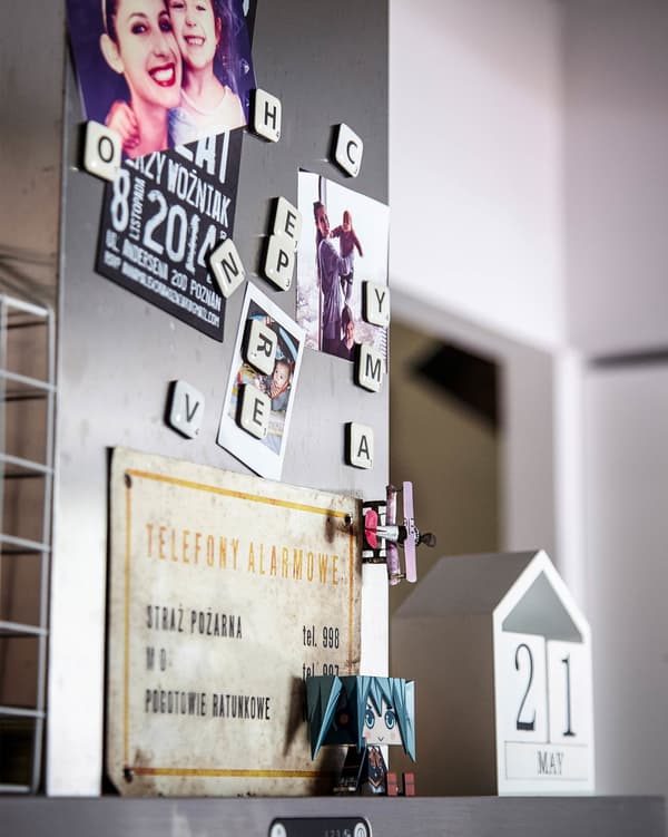 Family photos and mementos are displayed on the extractor fan above the hob.