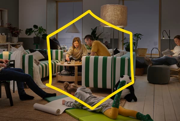 Family playing in the living room in the evenings, a teenage child is drawing on the floor.