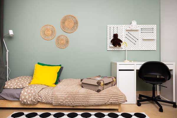 Family room suitable for toddlers and teenagers with bed, workspace, and wall decor.