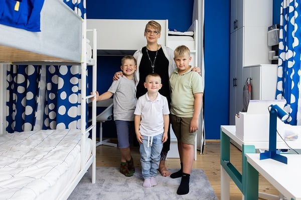 Family standing together in a modern children’s room with bunk beds and blue accents
