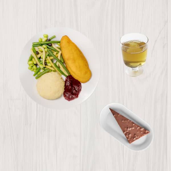 Farfurie cu șnițel, piure de cartofi, fasole verde și galbenă, edamame și sos de merișoare, alături de un pahar cu suc de mere și o farfurioară cu prăjitură de ciocolată.