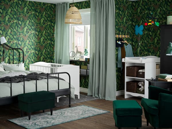 Fasciatoio e lettino bianchi, struttura letto nera e tende bianche/verdi in una camera da letto/cameretta dove domina il verde - IKEA