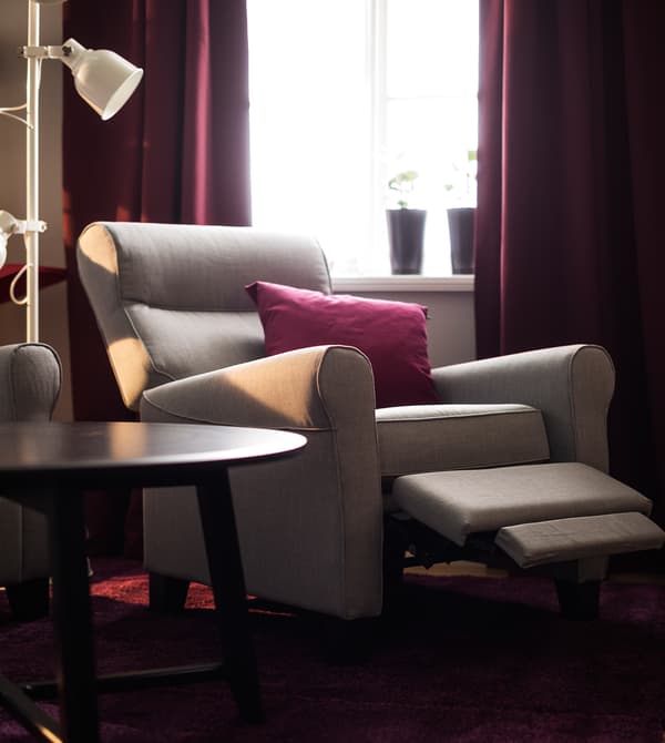 Fauteuil inclinable et table basse, installés devant une fenêtre.