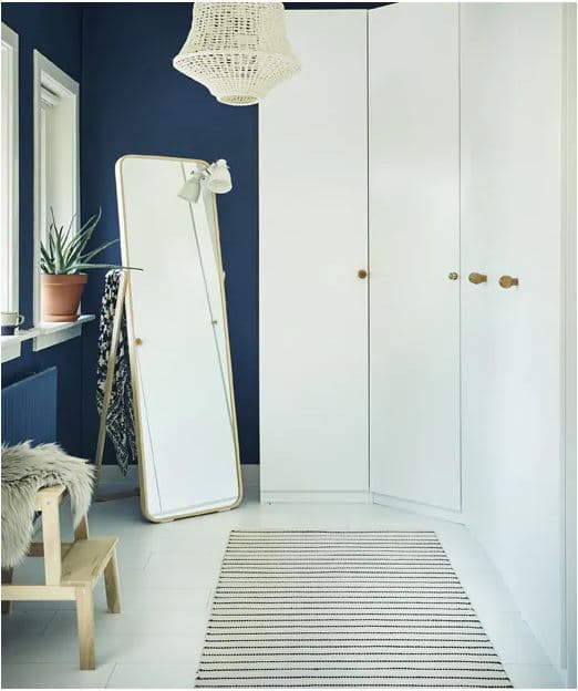 Fehér gardrób és tükör egy sötét szobában.