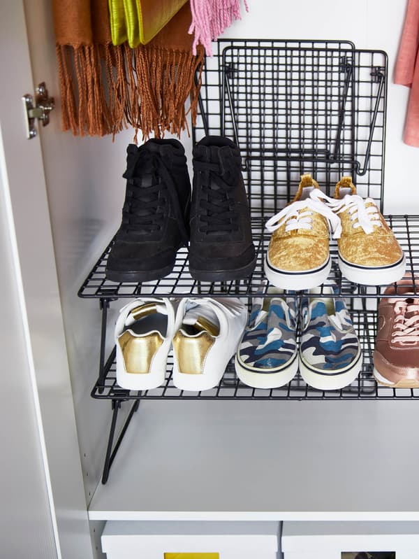 Fekete GREJIG cipőtartó egy fehér gardróbban.