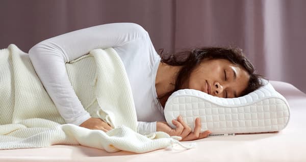 femme allongée sur le côté sur un oreiller ergonomique