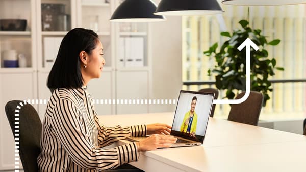 Femme assise sur son bureau en visioconférence.