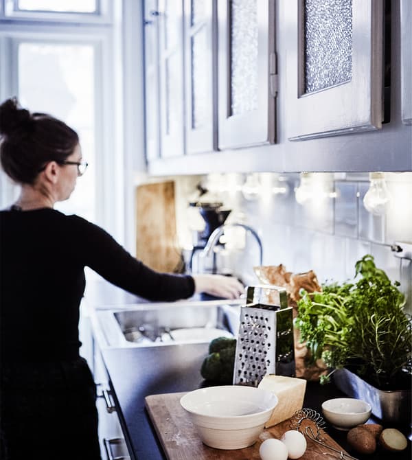 Femme devant l’évier de cuisine.