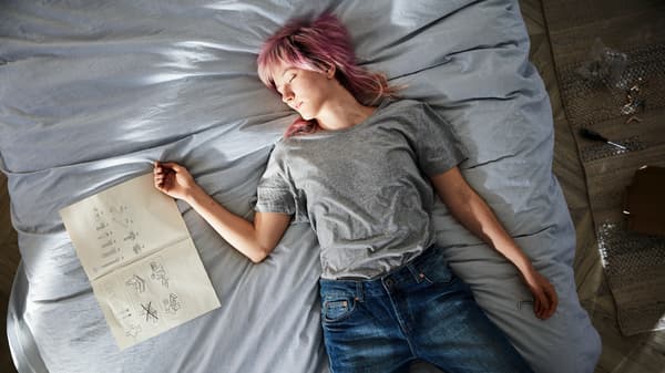 Femme dormant dans un lit près d'un livre 