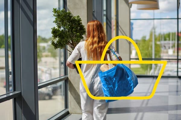 Femme en salopette de dos portant son sac IKEA rempli