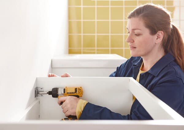 Femme en train de monter un meuble IKEA.