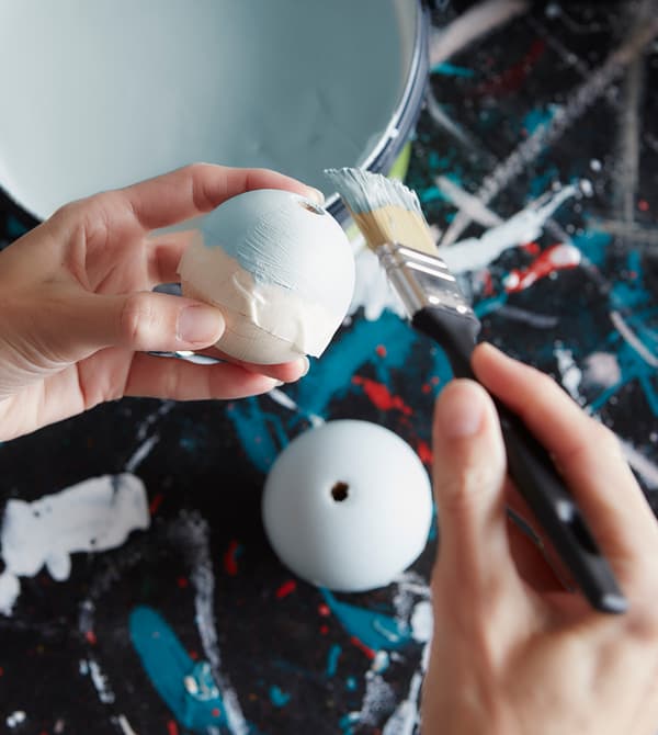 Femme en train de peindre des décorations.