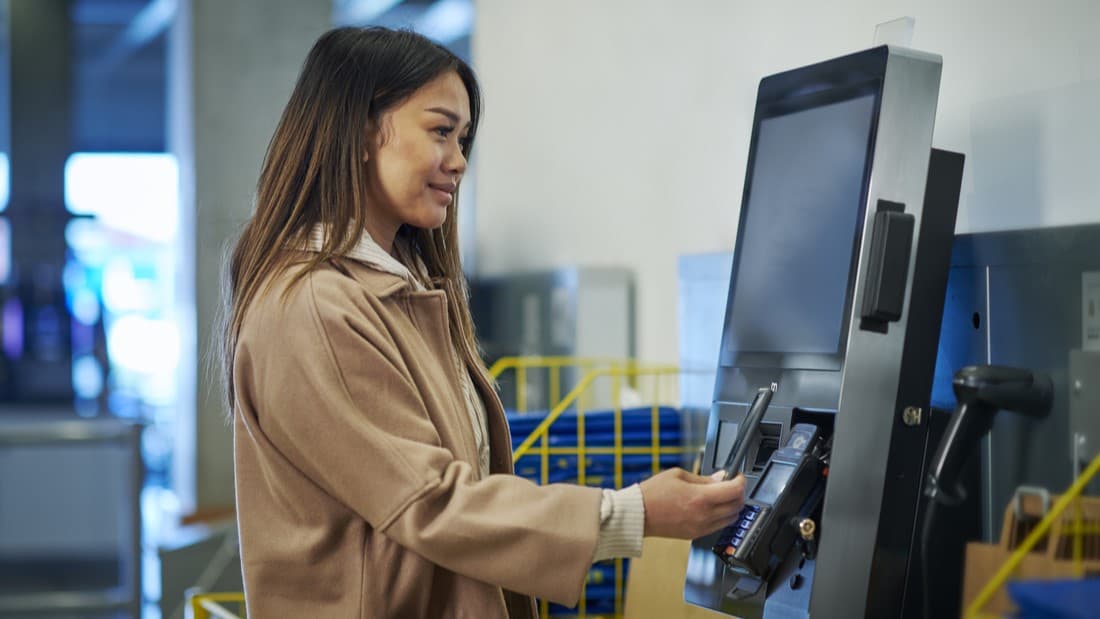 femme payant à la caisse automatique