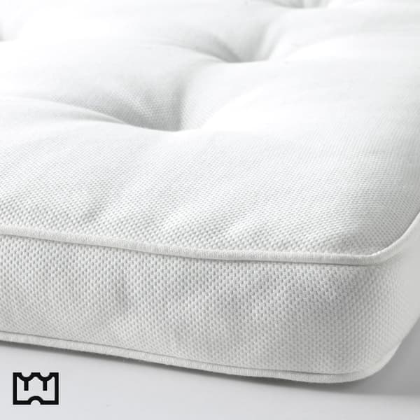 Femme qui ferme la fermeture éclaire d'un surmatelas en latex.