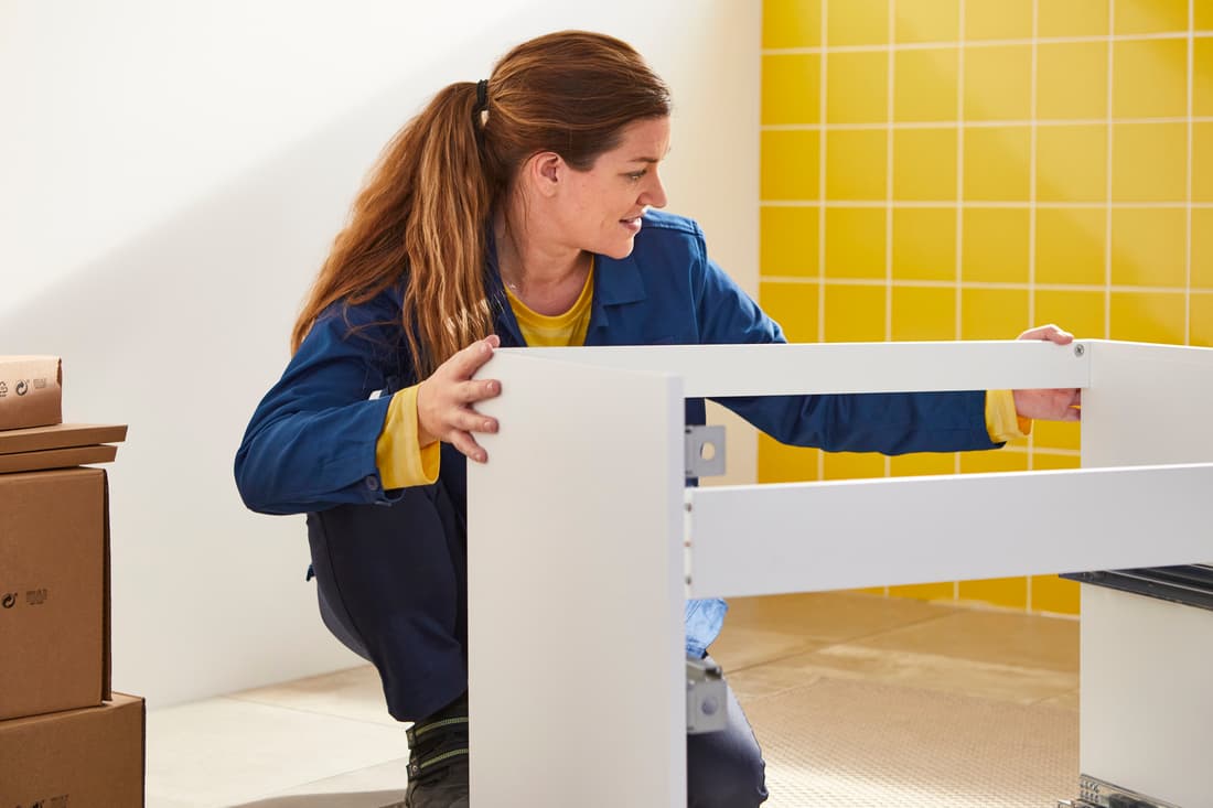 Femme qui monte un meuble.