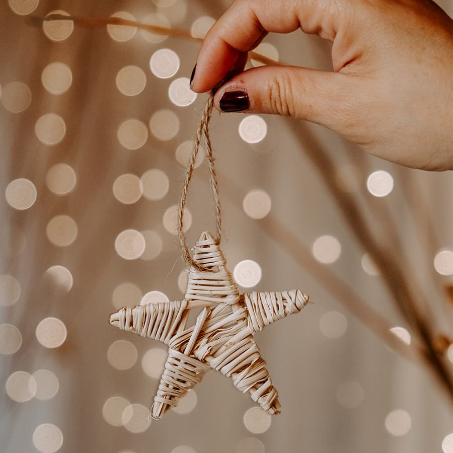 Femme qui tient une décoration de noêl en forme d'étoile fait à la main.