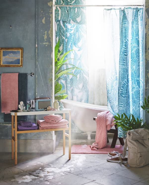 Fény szűrődik be a fürdőszobába és élénk színű kiegészítőket látunk.