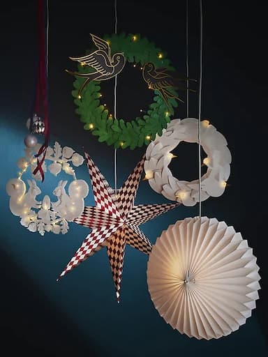 Festive paper decorations and lanterns hanging against a dark blue backdrop.