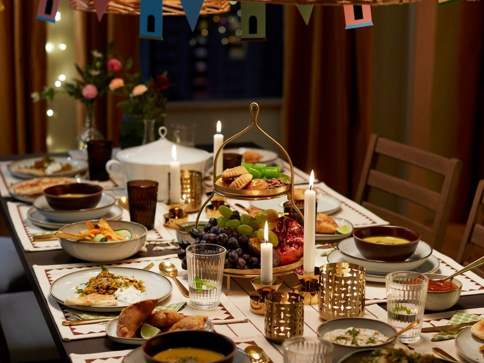 Festliga dekorationer, generösa kuddar och smyckade textilier. Dukning i glänsande mässingsfärger