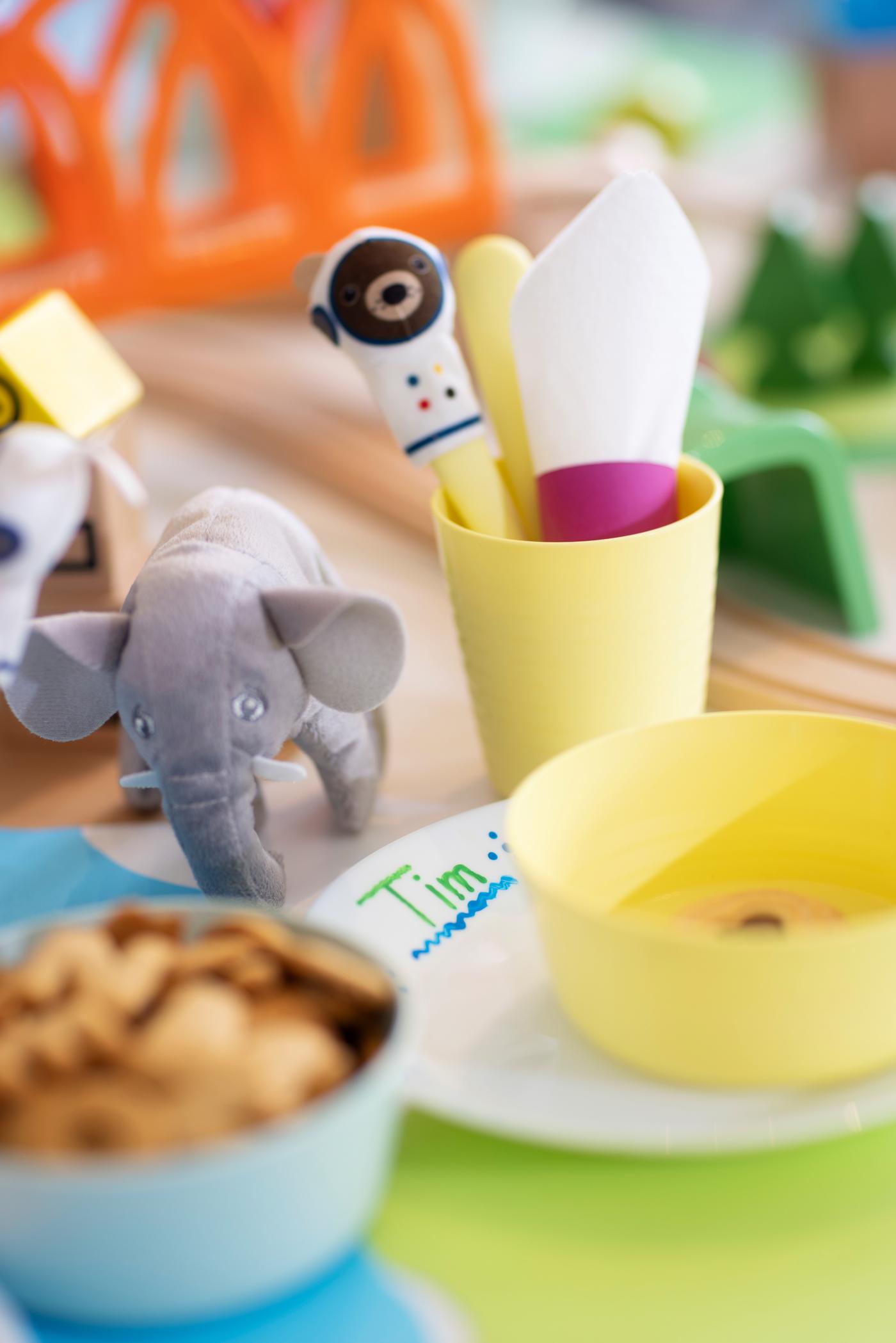 Fingerpuppen sitzen auf dem Besteck im gelben KALAS Becher dekoriert.