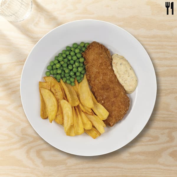 Fish and chips in un piatto bianco su un tavolo legno chiaro
