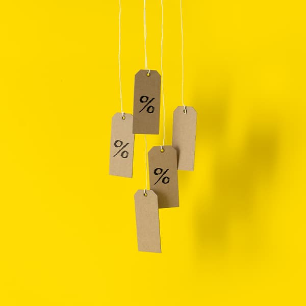 Five brown price tags with percentage symbols hanging from strings against a bright yellow background, symbolizing discounts or sales.