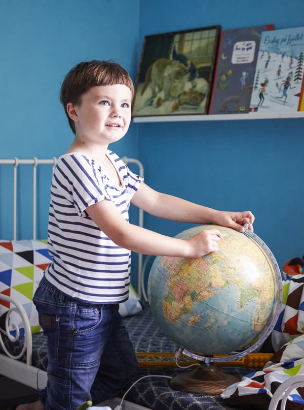 Five-year-old Viggo plays with a globe in his colourful bedroom.
