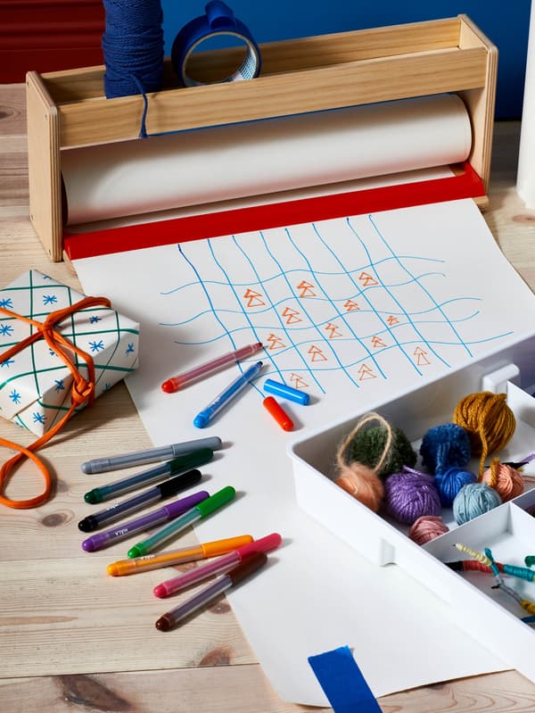 Fixky MÅLA ležia na pokreslenom papieri.