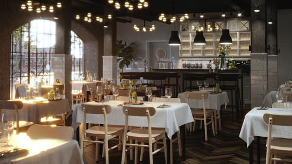 Flere TOMMARYD bord pent dekket med hvite duker, klare drikkeglass og blomster i en romslig restaurant.
