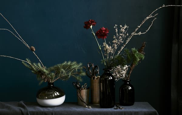 Flower presentations in vases of different sizes against a dark background.