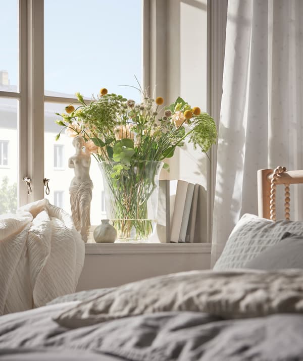 Flowers in a vase is a welcome addition of color to to contrast the spectrum of greige shades, like a light MATHEA throw.