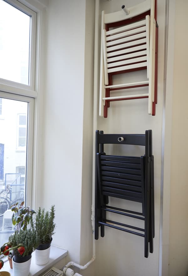Foldable chairs hanging on the wall.