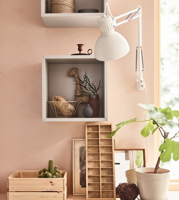 For peaceful home decor, choose what you want to have on display and group it. Use an open cabinet like this square, open, light gray EKET cabinet from IKEA to hold your favourite things in one place as focal points that are easier on the eyes.