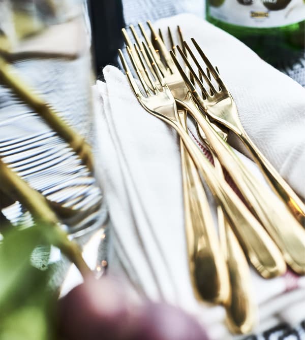 Forchette color ottone su una pila di tovaglioli.
