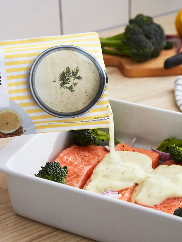 Forma na pečení IKEA 365+ s porcemi lososa a růžičkami brokolice, na které stéká citronovo-koprová omáčka LÄCKERGOM.