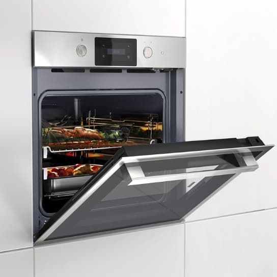 Forn d’aire forçat ANRATTA en acer inoxidable, encastat en una cuina moderna, amb diversos plats cuinant-se a l’interior.