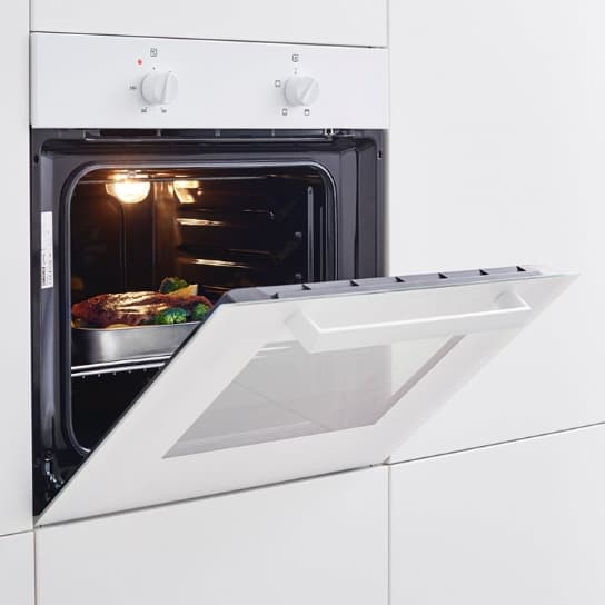 Forn tradicional LAGAN en blanc, instal·lat a una cuina encastada, amb la porta oberta i un plat al seu interior.