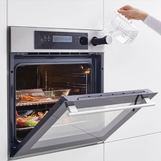 Forns d’aire forçat amb funció de vapor, amb dipòsit d’aigua integrat i diversos plats cuinant-se alhora a l’interior.