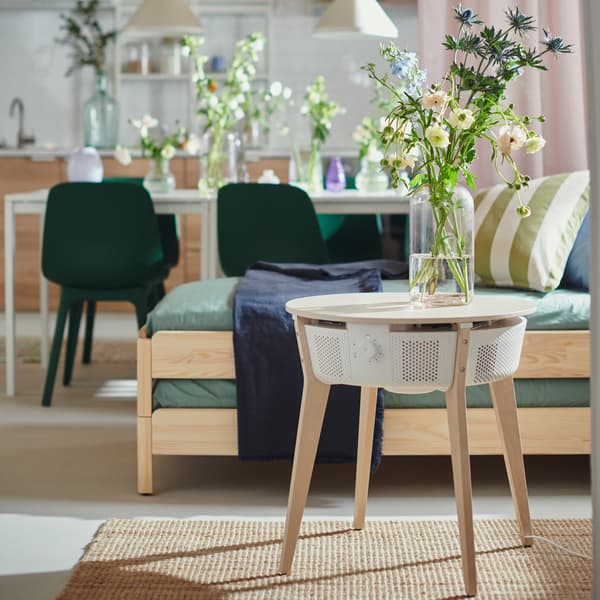 Foto av ett avlastningsbord där en en vas med blommor i står på.