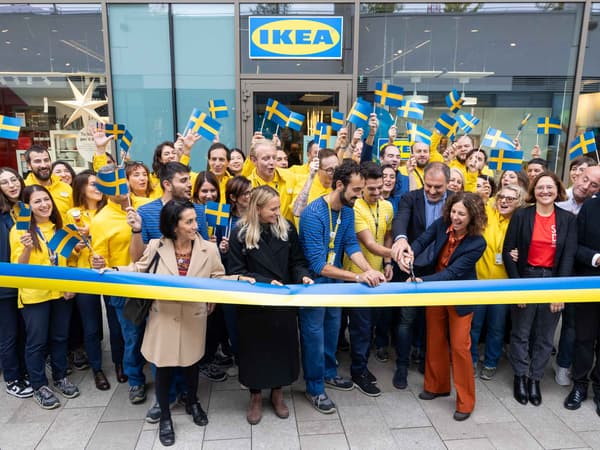 Foto dell'apertura del nuovo PLAN & ORDER POINT a CITYLIFE con tanti coworker felici che tagliano il nastro giallo e blu davanti al negozio.