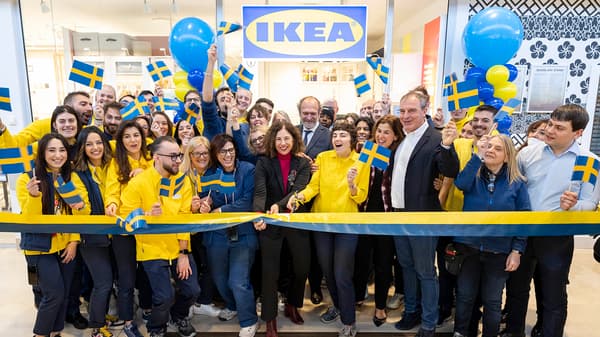 Foto dell'apertura di IKEA Como Plan & order point con tante persone che tagliano il nastro di apertura nel negozio.