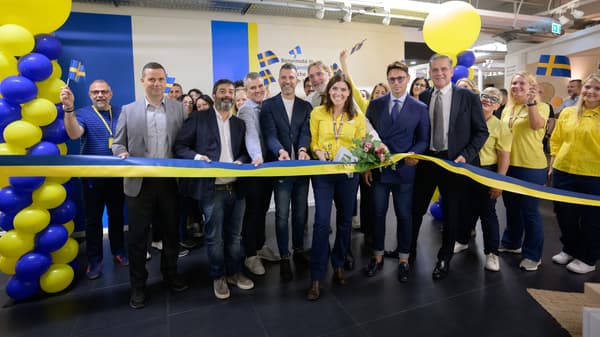 Foto dell'apertura di IKEA San Giovanni Plan & order point con tante persone che tagliano il nastro di apertura nel negozio.
