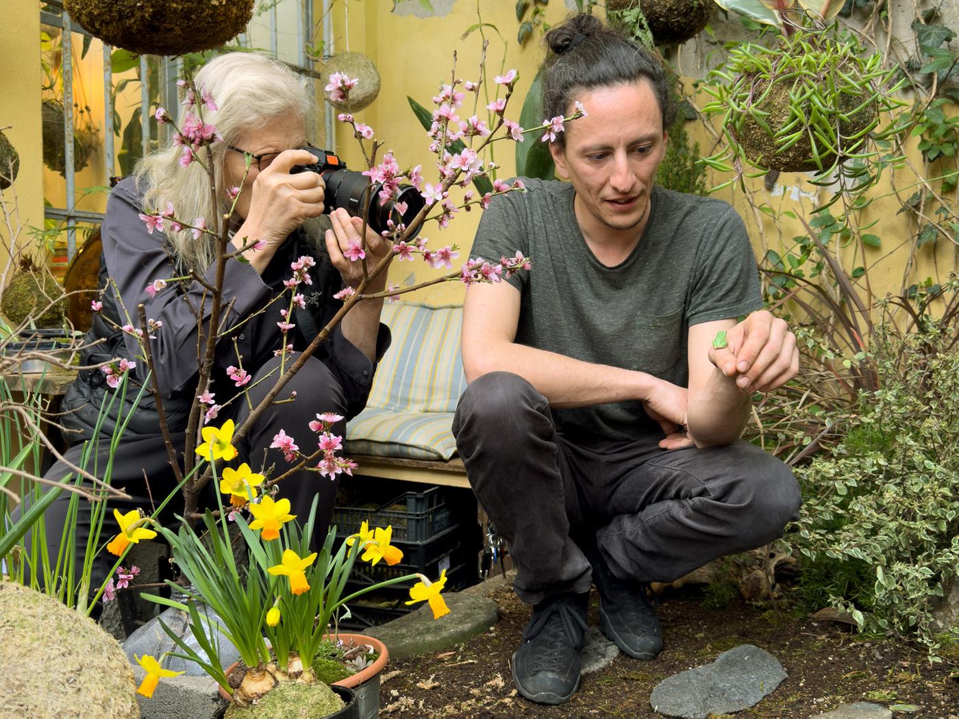 Fotografinja fotografira rastlino v rokah fanta.