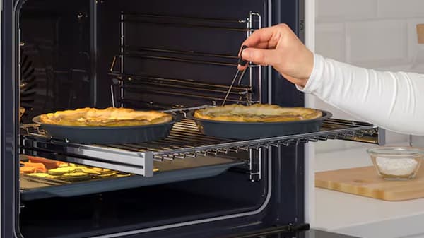 Four ouvert avec rail telescopique sorti, et deux plats sur la grille. 
