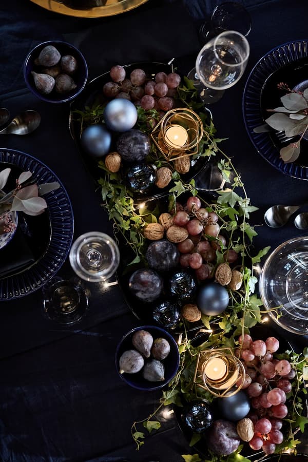 Four plates placed in the centre of a table and embellished with a dainty chain of fairy lights.