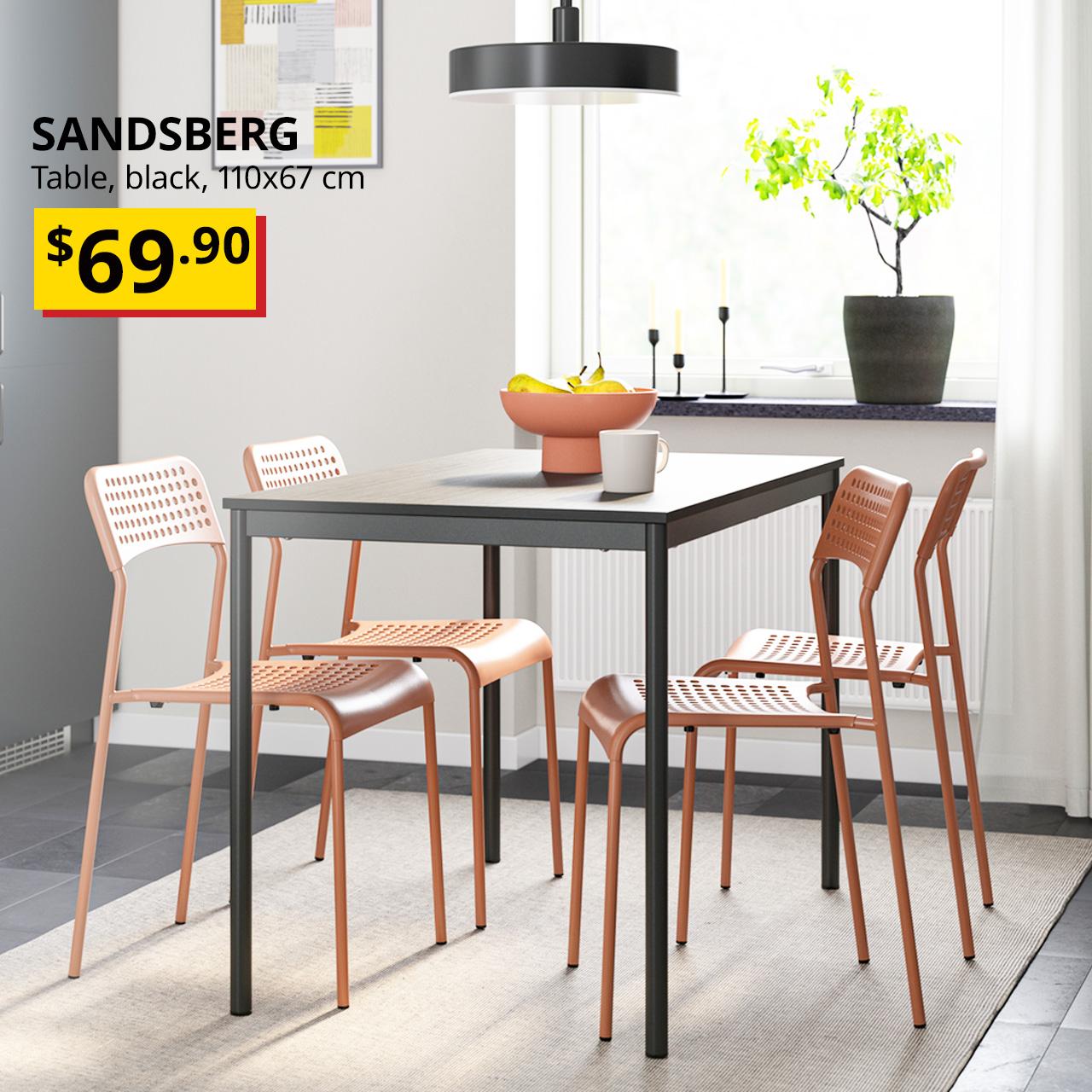 Four red SANDSBERG chairs tucked into a black SANDSBERG table, 110x67 cm, in a Singaporean dining room. Price: $69.90.
