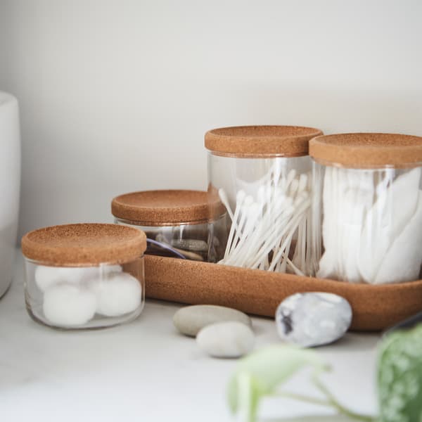 Four SAXBORGA glass jars in two different sizes with cork lids and a cork tray, holding cotton balls and Q-tips.